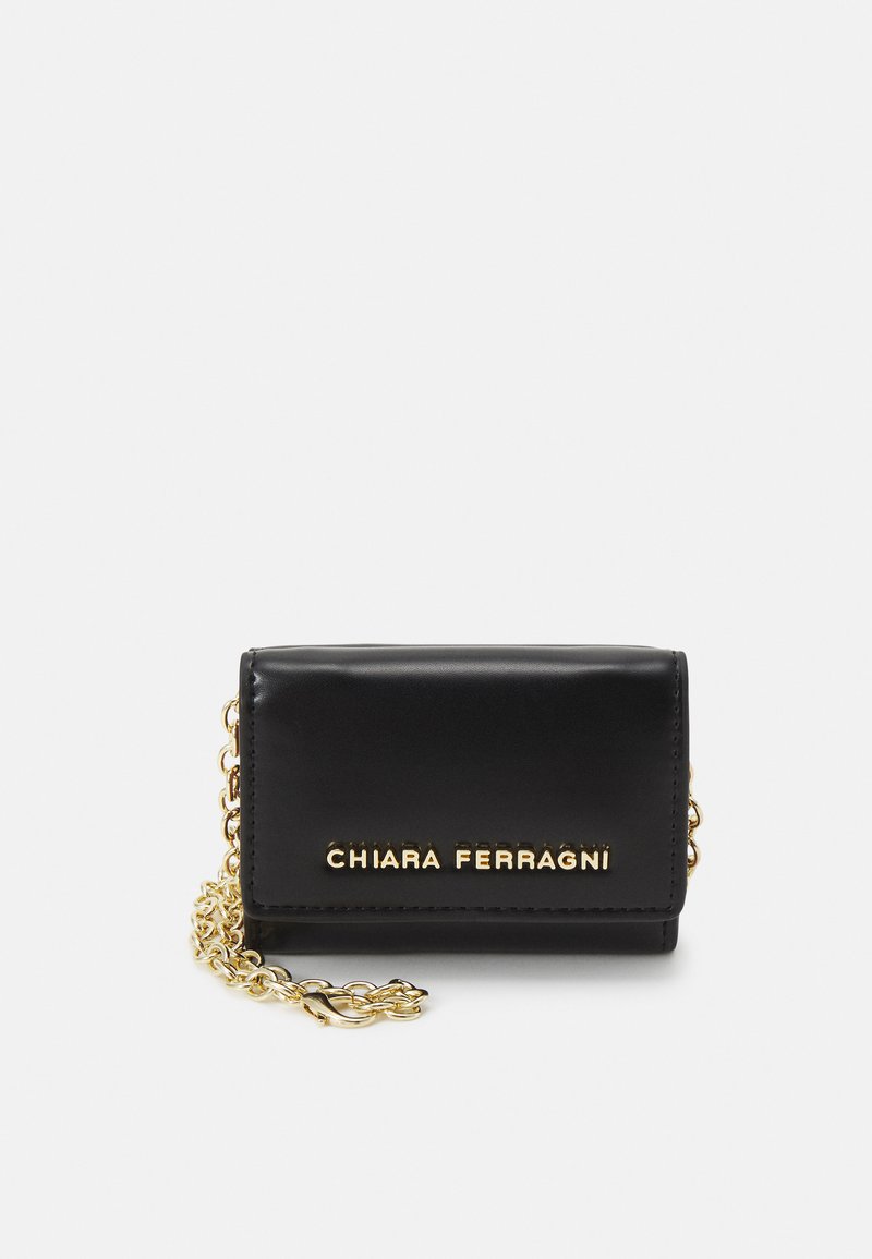 Sac à main en cuir noir, de forme rectangulaire, avec une bandoulière en chaîne dorée et le logo doré "CHIARA FERRAGNI" en relief à l'avant.