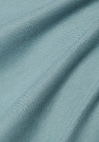 Hellblauer Strickstoff mit glatter Textur, der feine Muster und subtile Farbvariationen im Material zeigt.