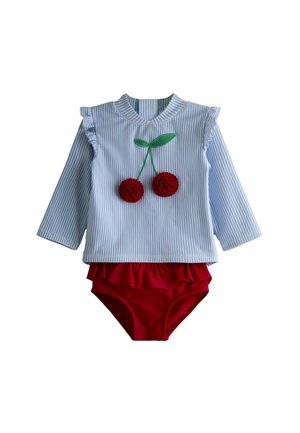 Haut pour bébé à manches longues rayé bleu et blanc avec volants aux épaules et appliqué cerise rouge, assorti à un bas rouge à volants.