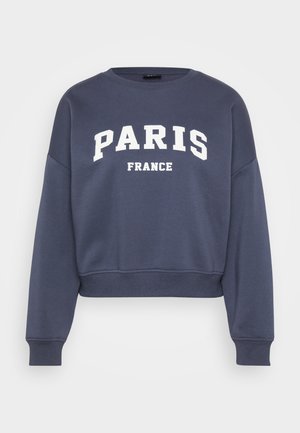 Sudadera corta azul marino de algodón con un texto blanco grande que dice "PARÍS" y "FRANCIA", con un ajuste relajado y puños acanalados.