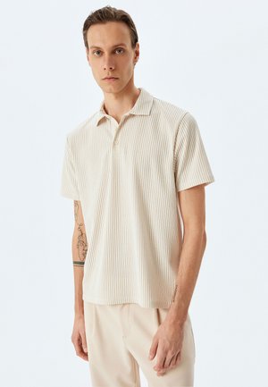 Polo de rayas beige con cuello, mangas cortas y una tapeta de tres botones. Presenta una textura de algodón suave.