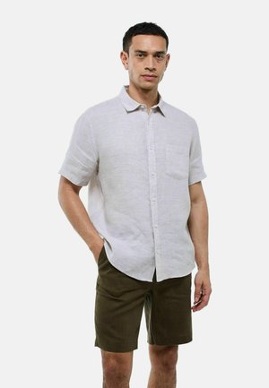 Chemise en lin courte à manches courtes gris clair avec un bouton sur le devant et une poche poitrine, assortie à un short vert foncé, se tenant devant un fond blanc uni.