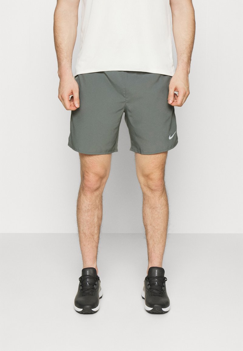 Shorts de sport pour hommes gris en tissu léger et évacuant l'humidité ; avec une taille élastique et un petit logo Nike blanc sur le côté.