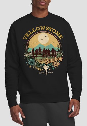 Black sweatshirt featuring a graphic design with "YELLOWSTONE," mountains, a moon, cowboy silhouettes, and a skull accent in earthy tones.
