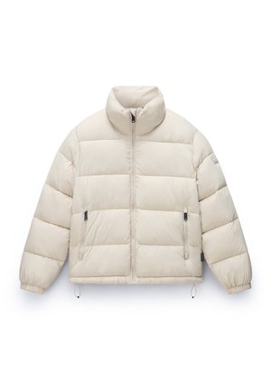 Bežs pūkains mētelis ar augstu apkakli, ar rāvējslēdzēju priekšā un elastīgām aprocēm. Iekļauj divas rāvējslēdzēju sānu kabatas un ir īsāks dizains.