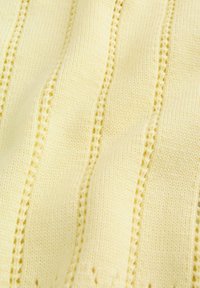 Tissu tricoté jaune clair présentant des rayures texturées et de petits motifs en œillets, créant un design subtil et rythmé sur toute la surface.