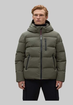 Chaqueta acolchada verde oliva con capucha, con acolchado horizontal, bolsillos con cremallera y cremallera frontal con detalles en contraste.