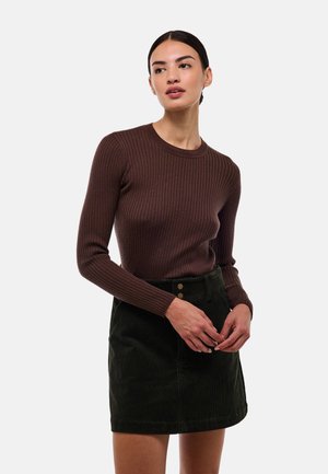 Haut marron côtelé à manches longues avec un col rond associé à une jupe mini en velours côtelé verte dotée de deux boutons à l'avant et d'une ceinture.