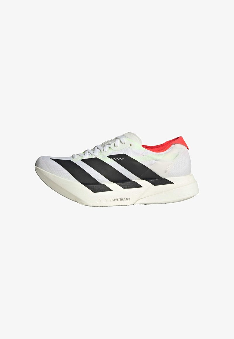 Tênis atlético branco com riscas pretas e calcanhar vermelho. Parte superior leve em malha, material texturizado e detalhes em padrão na sola.