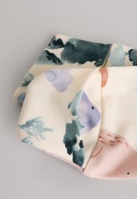 Accesorio para el cabello de tela en color crema con patrones florales en verde azulado, azul claro, lavanda y rosa suave. Textura lisa con diseño fruncido.