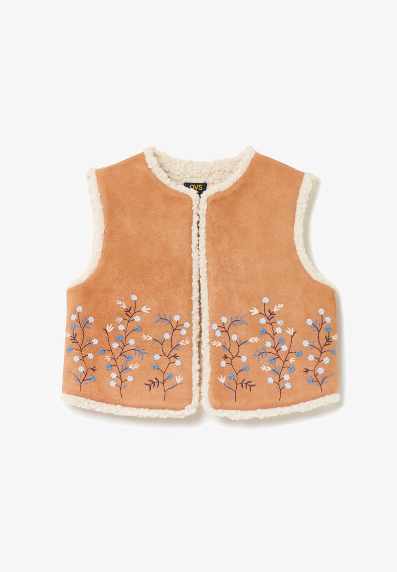 Gilet sans manches couleur fauve avec doublure en polaire blanche et broderie florale bleue le long des bords inférieurs, ouvert à l'avant sans boutons ni fermetures éclair.