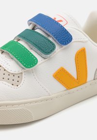 Weiße Ledersneaker mit grünen, blauen und orangefarbenen Klettverschlüssen sowie einer Gummisohle. Mit perforierter Zehenpartie und kontrastierendem Logodetail.
