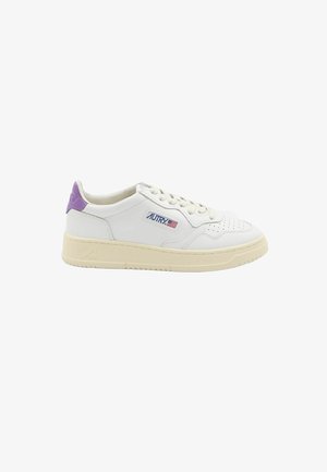 Witte lage sneaker met crèmekleurige zool, geperforeerde neus, paarse hieltab en Autry-logo met Amerikaanse vlag aan de zijkant.