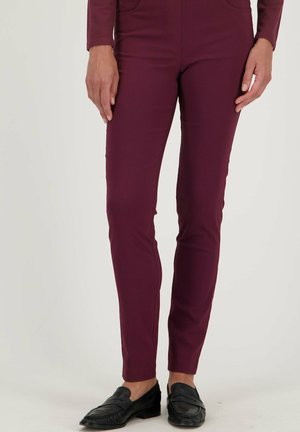 Bordeauxgekleurde fitted pantalons van zacht materiaal, met een normale taille, twee voorzakken en een gladde textuur. Gemaakt in combinatie met zwarte instappers.
