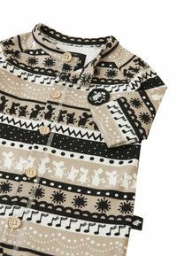 Koszula z krótkim rękawem w beżu, czerni i bieli z wzorem. Posiada guziki oraz różnorodne graficzne paski z motywami zwierzęcymi i geometrycznymi wzorami.