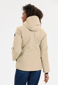 Beige hooded jacket met een gladde, licht glanzende textuur en een getailleerde pasvorm. Inclusief een zwart accentlogo op de mouw.