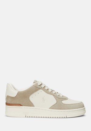 Beige suede and cream leather sneaker with round toe, lace-up closure, perforated detailing, and rubber sole. Features logo on side.