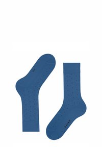 Blaue Baumwollsocken mit glatter Textur, die mit kleinen schwarzen und türkisfarbenen Punkten versehen sind. Der Markenname "FALKE" ist auf der Sohle sichtbar.