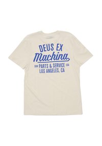 Cremefarvet bomulds t-shirt med blå trykt tekst på ryggen, der viser "DEUS EX Machina" og andre servicerapporteringsoplysninger i fed skrift.