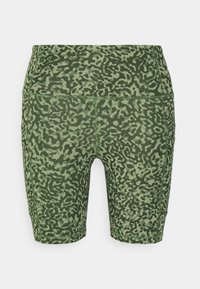 Calções de bicicleta verdes com padrão, apresentando um design de camuflagem em vários tons de verde, feitos de um material elástico e suave.
