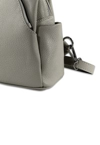 Gray leather handbag features a textured surface, a zippered pocket, and a detachable strap with metallic hardware.