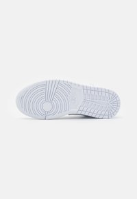 Biała podeszwa sneakersów z zaokrąglonym noskiem, poziomymi i pionowymi wzorami bieżnika oraz wyraźnym logo. Wykonana z gumy o chropowatej strukturze.