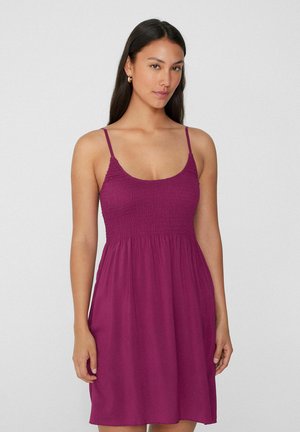 Kurzes lila Kleid mit gerafftem Oberteil, dünnen Spaghettiträgern und einem lockeren, fließenden Rock. Der Stoff hat eine weiche Textur.