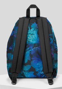 Plecak z czarną podstawą, zdobiony dużym niebiesko-fioletowym wzorem kwiatowym. W komplecie miękkie czarne paski oraz uchwyt do noszenia z góry.