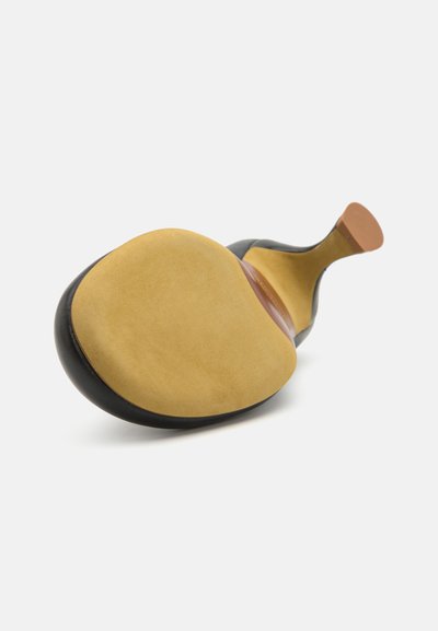 Sola de sapato preto com uma superfície amarela lisa e uma forma curvada. Seção do calcanhar em borracha na parte traseira, borda costurada e acabamento escuro.
