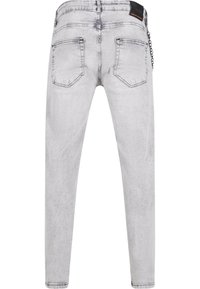 Jean slim en denim gris clair avec un délavage subtil, design à cinq poches et un détail en chaîne au niveau de la taille. Fini texturé sur l'ensemble.