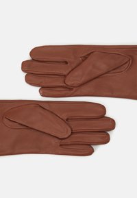 I guanti in pelle marrone presentano una texture liscia, un design a cinque dita e un accento unico sul dito indice per un facile utilizzo.