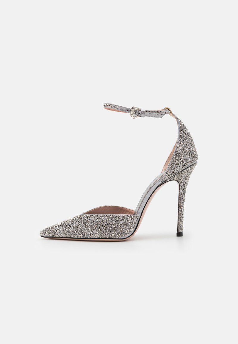 Silver high-heeled pump with pointed toe, embellished with rhinestones. Features an ankle strap with a buckle and a stiletto heel.