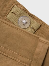 Bouton en plastique transparent attaché à une sangle en tissu beige ajustable sur la ceinture d'un vêtement en coton marron cousu.