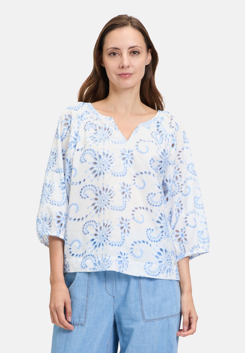 Lichtgewicht blouse met een blauw en wit patroon, driekwart pofmouwen, V-halslijn en bloemachtige krullen in een doorzichtige stof.
