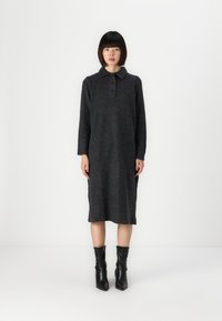 Rochie gri cărbune cu guler, mâneci lungi și închidere cu trei nasturi. Material moale și texturat care ajunge până la jumătatea gambei. Botine negre.