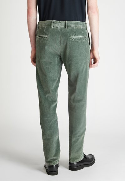 Zielone spodnie z korduroju o strukturalnym wykończeniu, z klasycznym paskiem w talii, szlufkami na pasek i dwiema tylnymi kieszeniami. Slim fit.