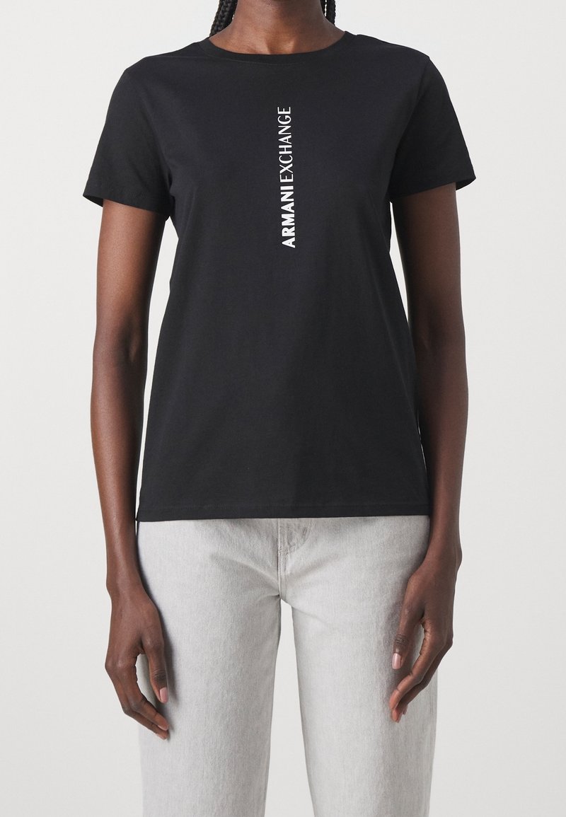 Czarny bawełniany T-shirt z krótkim rękawem, z pionowym białym nadrukiem logo "ARMANI EXCHANGE" z przodu. Klasyczny dekolt w serek.