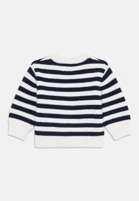 Ριγέ πουλόβερ σε ναυτικό μπλε και λευκό, με ραβδωτή υφή, στρογγυλή λαιμόκοψη και μακριά μανίκια. Η πίσω όψη δείχνει εναλλασσόμενες ρίγες.