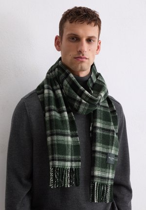 Green and black plaid scarf made of soft fabric with fringed ends; features a textured pattern and a small brand label on one side.