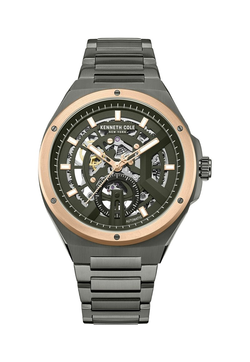 Automatisch uurwerk met een ronde kast, groene wijzerplaat, skeletontwerp, goudkleurige accenten en een roestvrijstalen band. Bevat uurmarkeringen en datumaanduiding.