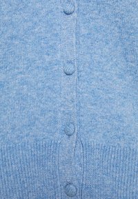 Cardigan blu lavorato a maglia con tessuto testurizzato, bottoni rotondi e polsini a coste. Il design è semplice e uniforme in tutto.