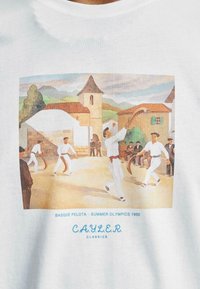 Camiseta de algodón blanca con una ilustración colorida de jugadores con vestimenta tradicional jugando a la pelota vasca, con texto en la parte inferior.