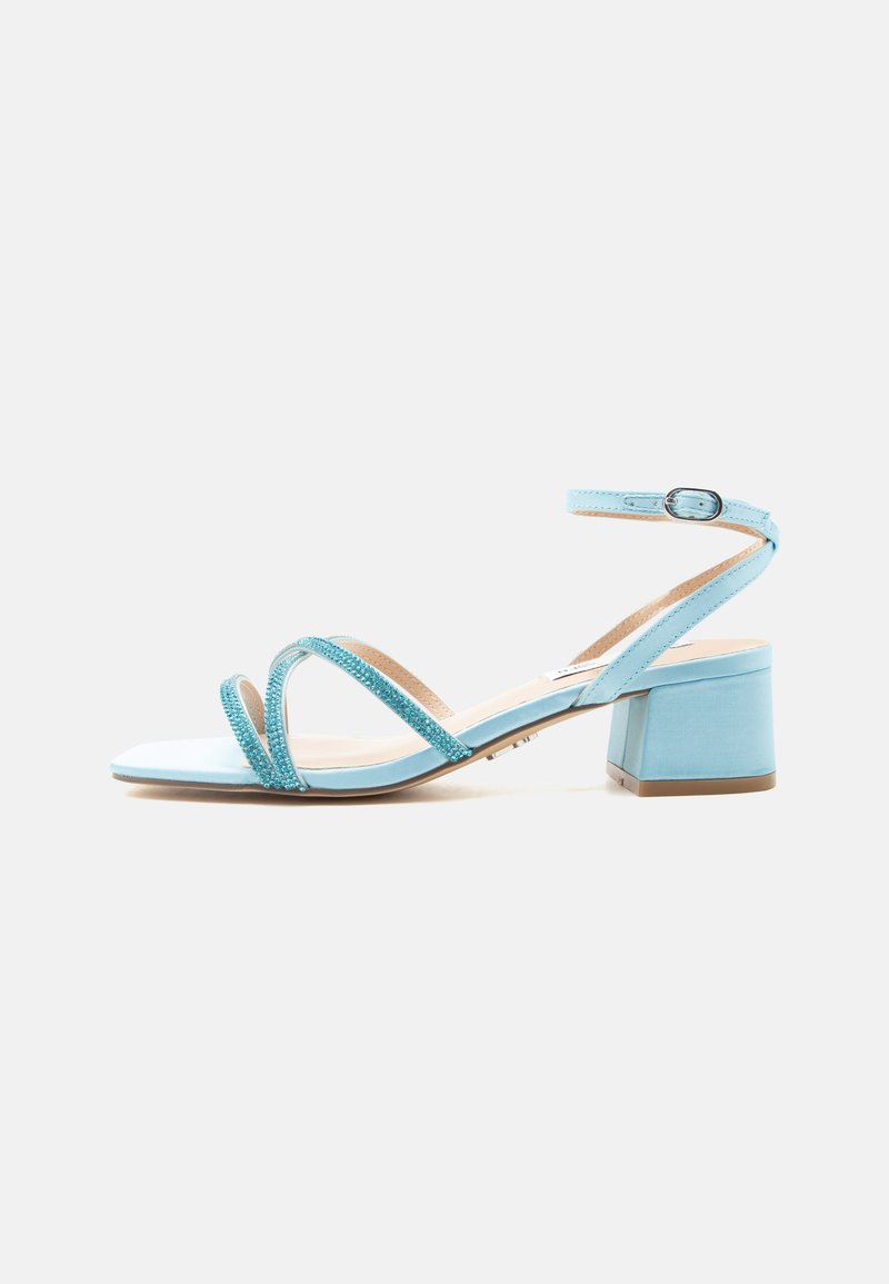 Sandale à talon bleu clair avec deux brides avant ornées de petites perles, une bride à la cheville avec boucle, et un talon bloc.