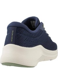 Scarpe da ginnastica blu navy con tomaia in rete traspirante, suola bianca imbottita e dettagli testurizzati sul tallone, marchiate 'Skechers'.