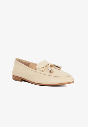 Mocassin en cuir beige avec un bout arrondi, petit talon brun et éléments décoratifs en or avec des franges à l'avant. Texture lisse.