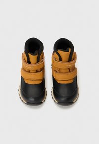Botas para toddlers en negro y marrón con dos correas de velcro, suela de goma, cuello acolchado y texturas contrastantes. Diseño resistente para uso exterior.