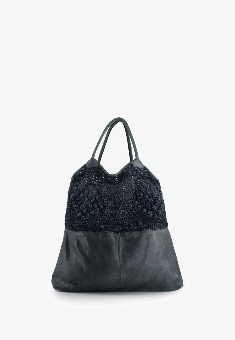 Stor shopper lavet af mørkt vævet stof med teksturerede detaljer og en glat læderbund; har buede håndtag og et rummeligt indre.