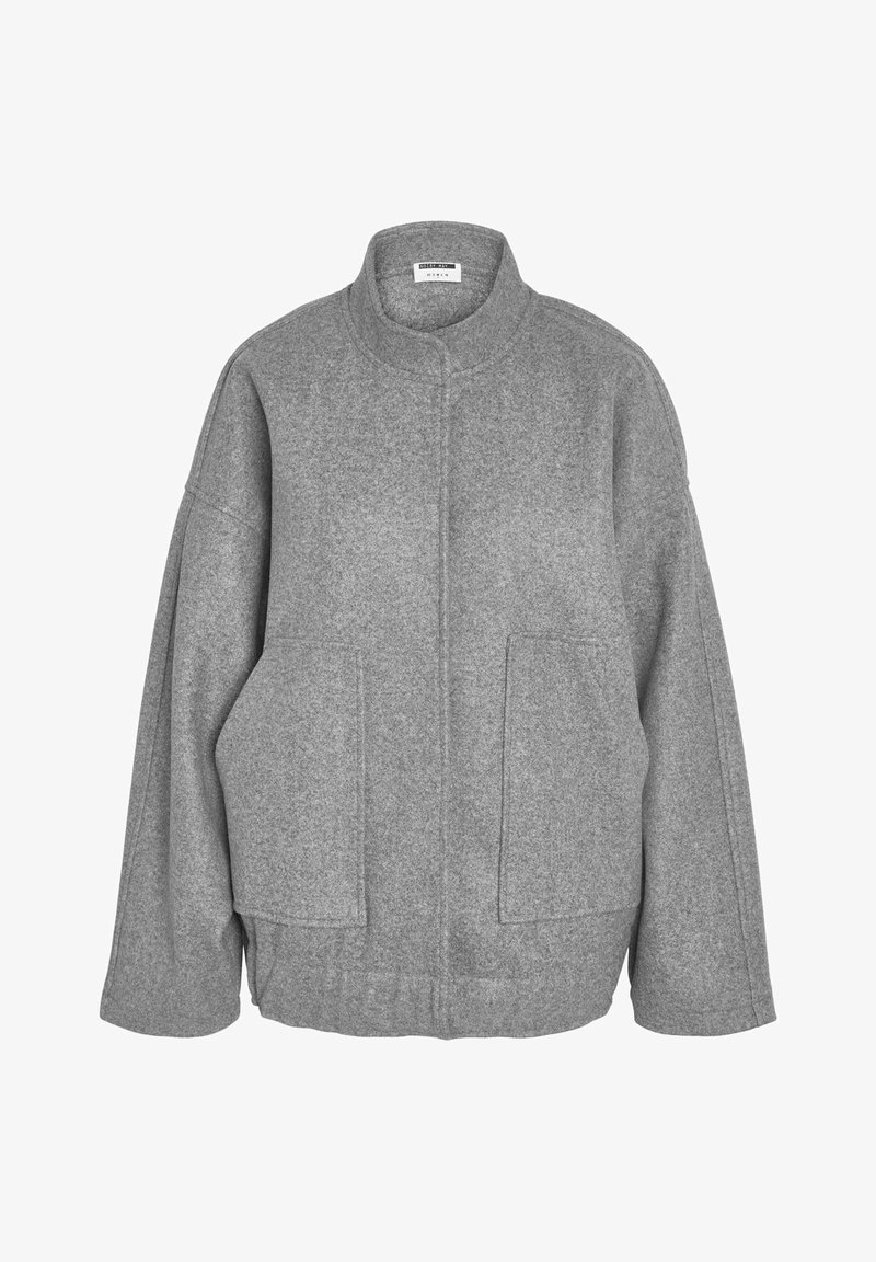 Giacca grigia in misto lana con taglio oversize, colletto alto, due tasche frontali e spacchi laterali per comfort e libertà di movimento.