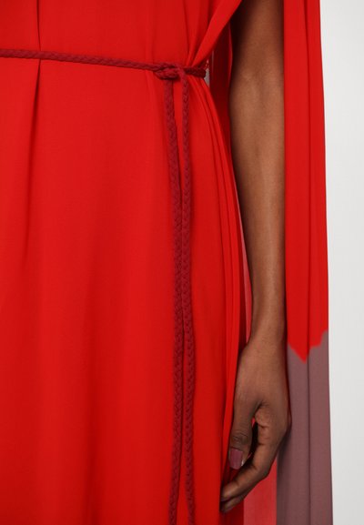 Red flowing dress featuring a braided waist tie, with a smooth texture and draped sleeves transitioning into a gradient of color.