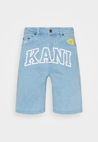 Jasnoniebieskie szorty dżinsowe o luźnym kroju, z białym napisem "KANI" i żółtym wzorem graficznym na tylnej kieszeni.